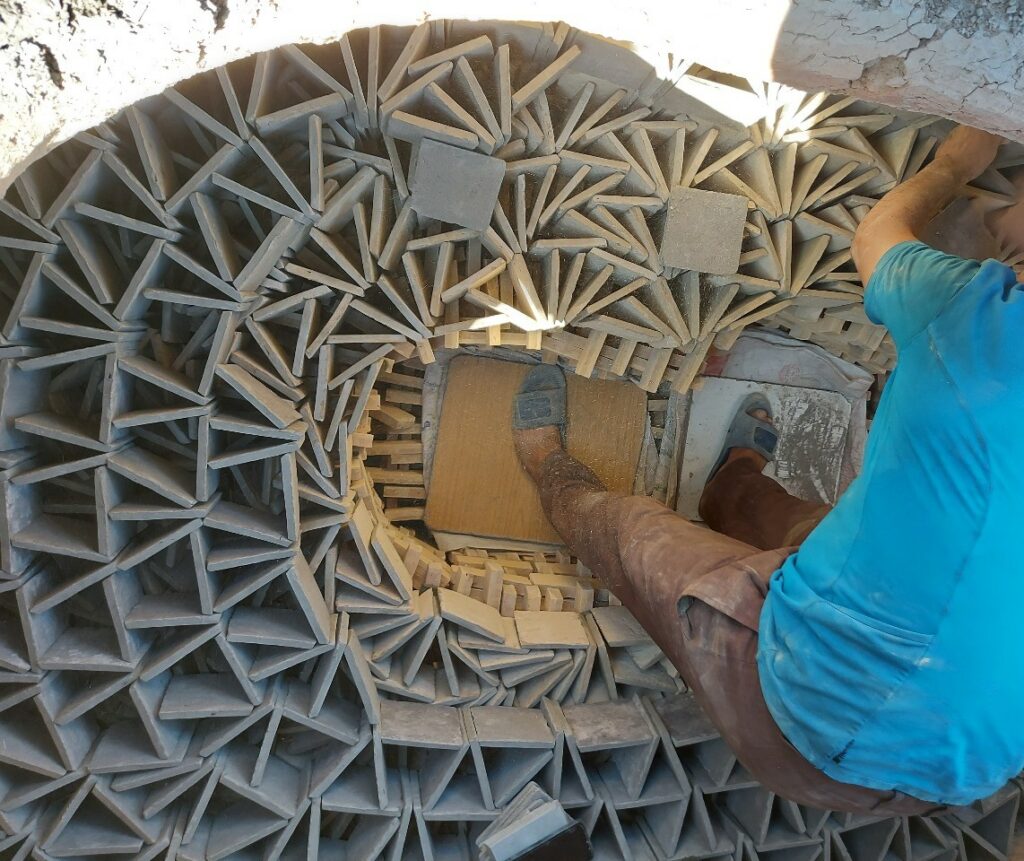 un artisan placent les carreaux au four