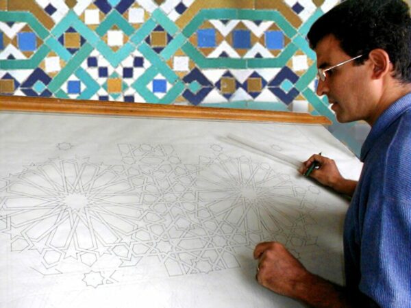 Ahmed Zinoun travaillant un plan, sur une table d'architecte