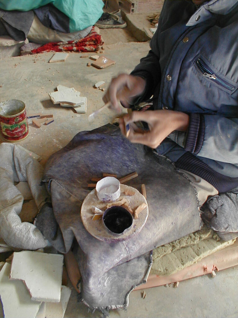 artisan sur ces genoux traçant des motifs